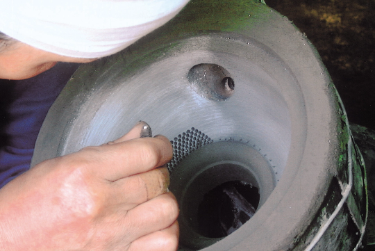 霰（あられ）押し棒という道具を使い、鉄瓶の表面に浮き出る紋様をひとつひとつ手作業で鋳型に押していく。さ。