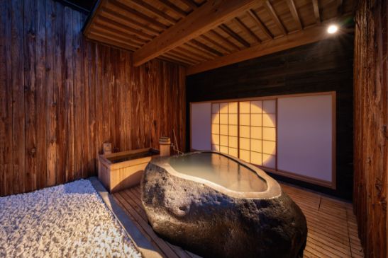 瞑想をテーマにした貸し切りの岩風呂。畳の間の灯りで丸窓が月のように浮かび上がる