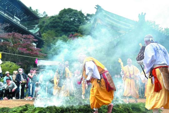 1200年以上燃え続ける「消えずの霊火」で檜の青葉を燃やし、残った火の上を素足で歩く「火渡り式」。次回は4月15日（火）開催で、誰でも無料で参加可能。