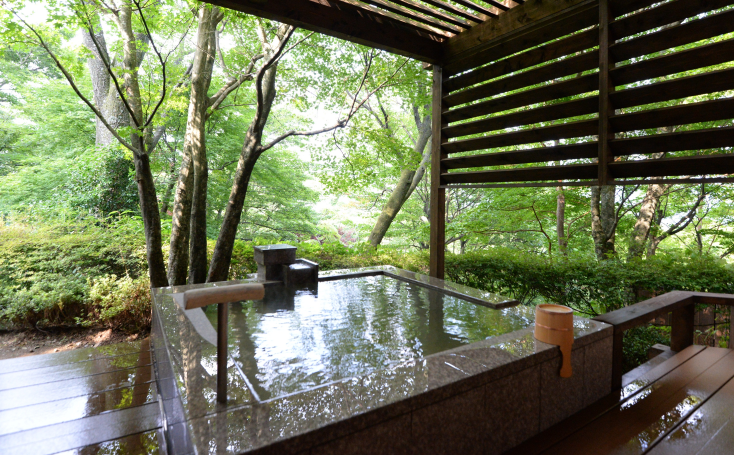 スイート客室「萬（Man）」の源泉かけ流し露天風呂。デッキのチェアに身を預け、箱根の自然を望みながら湯上りの時間を過ごせる