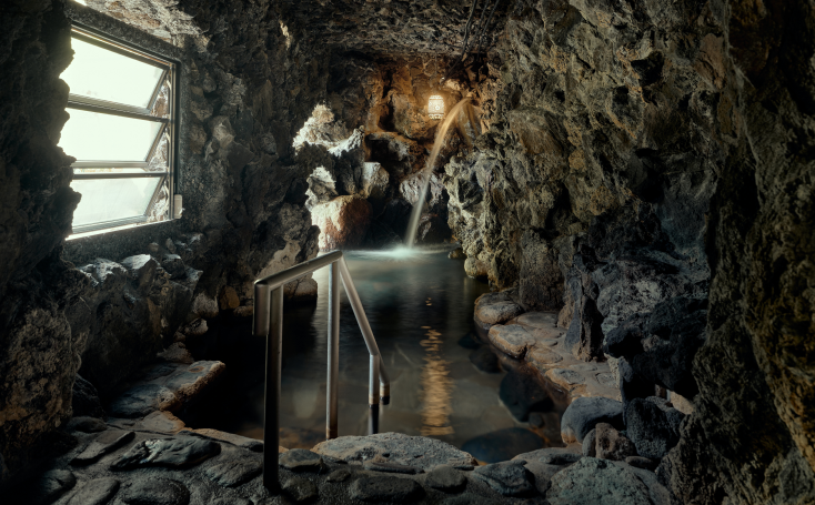 野趣にあふれる「天狗の湯」の洞窟風呂はリニューアルで開放感が高まった。渓流のせせらぎが静謐なひとときを演出する