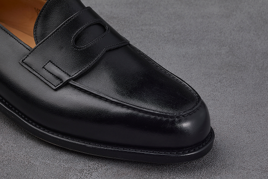 フロントエプロンの精緻なカーブを描く縫い目こそ、熟練の職人技の証。ステッチが放つ静かなる風格が、履き込むほどに味わいを深める。