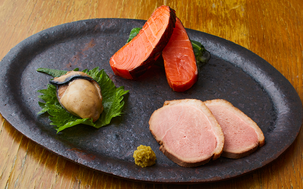 コースの八寸としても提供している「前菜三種盛」は、炙りスモークサーモン、鴨のロース、牡蠣の醤油煮など、旬の味覚を使用。季節ごとに違った味わいが愉しめる。