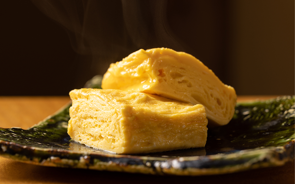 銅鍋で丁寧に巻き上げた特製の「だし巻き玉子」。軽快な飲み口の後に、純米酒らしいお米の優しい旨みが口いっぱいに広がる日本酒「緑川 純米」との相性は抜群。