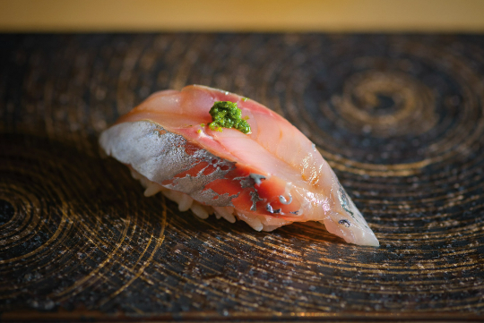 [アジ] 鹿児島県産のアジ。塩で〆て寝かせる江戸前鮨の伝統技法が光る。旨みが引き出され、まろやかになったアジは、多くの人を魅了する。