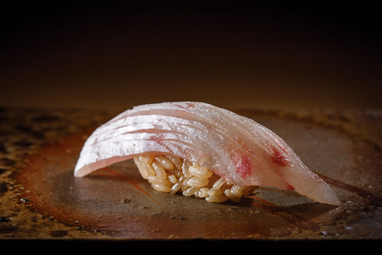[真鯛] 塩をふり2日間熟成させることで、ねっとりとした食感と旨みが生まれる明石産の天然真鯛。すだちの酸味がアクセントに。350円。